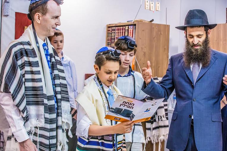 上图:一个犹太男孩在成为「诫命之子 Bar Mitzvah」的成人礼上诵读经文,他的前额上带着经文匣(Tefillin),身上披着祷告巾( Tallit)。犹太教男孩到了13岁,在律法上就和成年人有同样的权利和义务,被称为「诫命之子」。「诫命之子」每天都必须佩戴经文匣,并被安排在会堂中诵读妥拉、先知书和唱颂圣歌,带领聚会和公祷。犹太男孩在成人礼之前,由父母在神面前为自己的行为负责,而在成人礼之后,必须自己向神负责。因此,只有「诫命之子」,才可以「向耶和华许愿或起誓,要约束自己」(民三十2)。