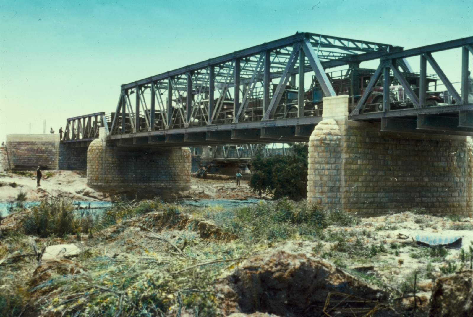 上图:重建于1930年代的艾伦比桥(Allenby Bridge),可以看出非洪水季节约旦河的水面宽度、高度。艾伦比桥又名侯赛因国王桥(King Hussein Bridge),横跨耶利哥附近的约旦河,通往约旦。艾伦比桥由英国将军Edmund Allenby始建于1918年,后经反复破坏、重建,目前是西岸(West Bank)巴勒斯坦人唯一的出境关口。